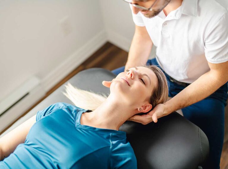 A chiropractor gently adjusts an adult patient's spine in a comfortable clinical setting.